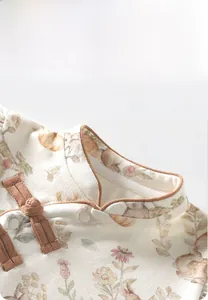 Detail von Baby-Einteiler aus Bio-Baumwolle mit Blumenmuster und Knotenknopf