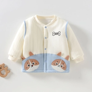 Detailopname van gebreid babyvest met schattig hondenborduurwerk en blauwe knopen