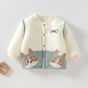 Detail van gebreid babyvest met cartoon hondenzakken en houten olifant decoratie
