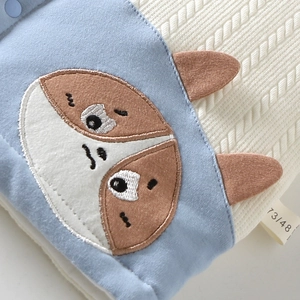 Close-up van babygebreid vest met schattig kattenborduurwerk en 3D-oordetails