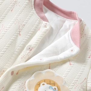 Detail of baby quilted cotton cardigan featuring cartoon lion embroidery and snap buttons