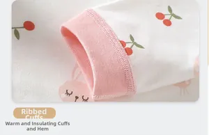 Détail des poignets côtelés du pyjama bébé avec motifs de cerises et de lapins roses