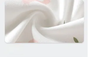 Détail du tissu en coton doux pour barboteuse bébé avec imprimé dessin animé rose et vert
