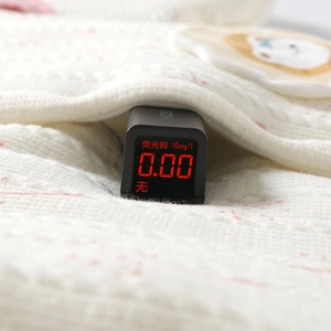 Detail showing baby knit sweater fabric tested for zero fluorescence safety