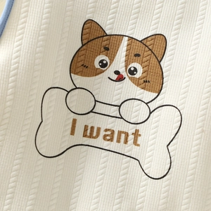 Macro-opname van gebreid babyvest met een schattige hond die een I want bot vasthoudt