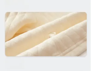 Detailed macro view of cream-colored quilted cotton fabric with diamond pattern