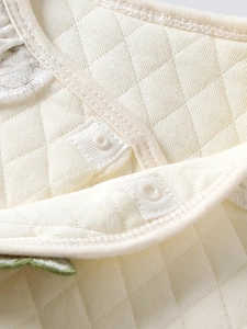 Cream quilted baby vest with diamond pattern and resin buttons for infant warmth