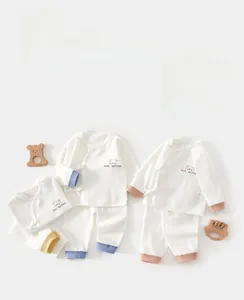 Detail of waffle knit cotton baby pajamas featuring Bear Brother embroidery and side ties