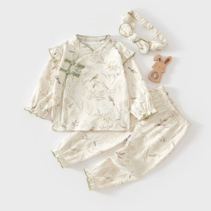 Détail d'un ensemble trois pièces en coton pour bébé avec motifs d'oiseaux et volants