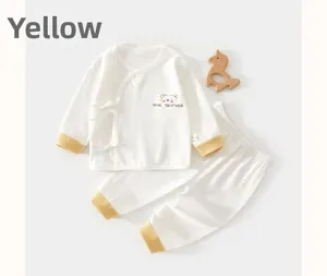 Flat lay of baby cotton pajama set with yellow accents and bear brother print decoration