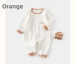 Detail of baby cotton romper featuring side snap buttons and cartoon bear print