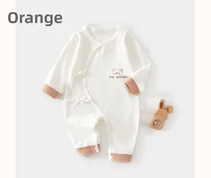 Détail d'une barboteuse bébé en coton avec broderie ours et fermeture à nouer