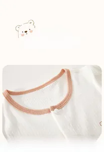 Macro detail of breathable cotton baby cardigan with soft pink ribbed round neckline