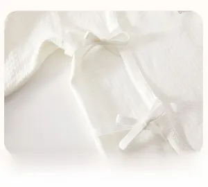 Detail of baby summer sleepsuit featuring breathable waffle texture and soft side-tie closures