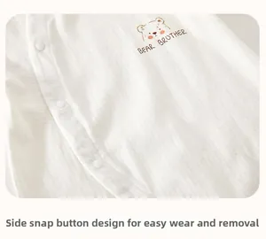 Detail of baby cotton jumpsuit featuring side snaps and a cute bear brother print