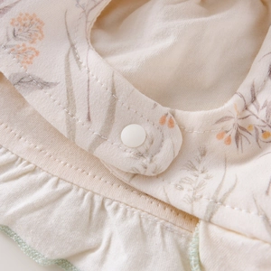 Détail du chapeau bébé en coton à fleurs avec volants et bouton pression en résine