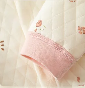 Detail of baby quilted top showing pink ribbed cuffs and floral diamond pattern