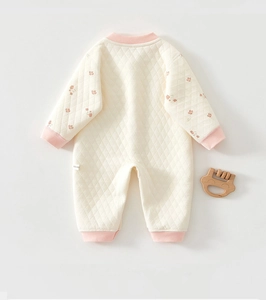 Close-up of quilted floral baby romper showing delicate diamond texture and size label