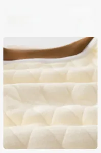 Détail du tissu en coton matelassé beige avec motif de losanges et ourlet marron bébé