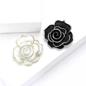 Ensemble de broches camélia en émail noir et blanc avec des bords dorés perlés élégants