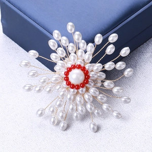 Vue détaillée d'une broche en perles tissées main avec perles rouges et fils dorés
