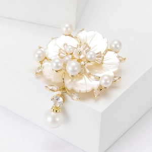 Broche camélia élégante avec pétales en nacre, perles et pendentif doré luxueux