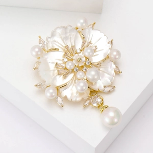 Broche fleur perle élégante avec nacre et zircons brillants sur support en métal doré