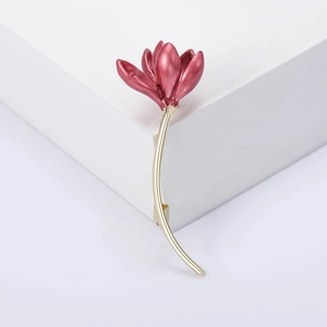 Detail of elegant magnolia flower brooch featuring deep pink enamel and gold-plated long stem