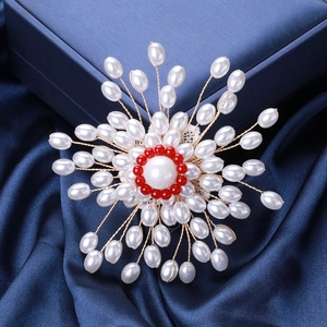 Détail macro d'une broche fleur faite main avec perles d'imitation et cœur rouge