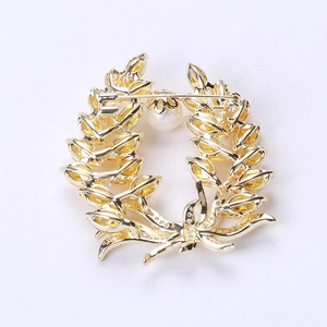 Close-up of wheat brooch with yellow marquise gems, golden base and pearl detail