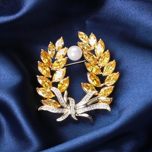 Golden wheat brooch with yellow marquise stones, a pearl, and a diamond bow knot