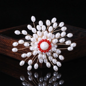 Détail de broche ronde en perles faites à la main avec centre rouge et fil doré
