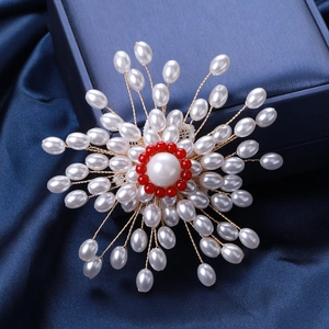 Détail de la broche ronde en perles faite main avec perles rouges et fils dorés