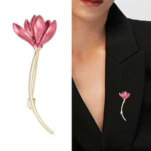 Elegant magnolia flower brooch in pink enamel with gold stem on black blazer lapel