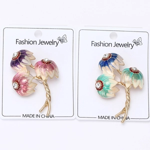 Detail of enamel lotus brooches with crystal accents and gold-tone stems in two colors