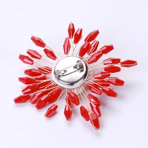Detailed back view showing the silver safety pin buckle on a red beaded flower brooch