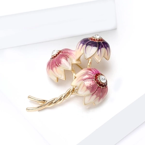 Macro detail of three-flower enamel brooch with golden finish and clear rhinestones