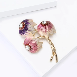 Detail view of enamel flower brooch with sparkling rhinestones and golden branches