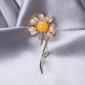 Detailed close-up of a floral daisy brooch with zircon inlay and amber bead center