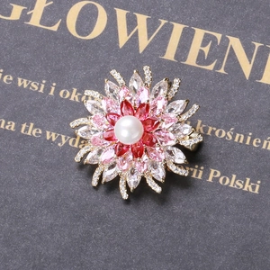 Détail macro d'une broche tournesol avec perle blanche, zircons roses et cristaux