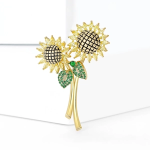 Elegante zonnebloem broche met gele edelstenen en groene zirkoon op gouden basis
