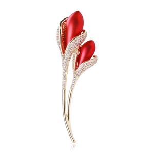 Macro detail of red calla lily brooch with gold plating and sparkling zircon pavé setting