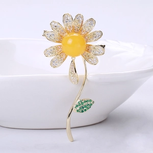 Close-up of elegant daisy brooch with amber-like center and micro-pave zircons
