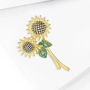 Fonkelende zonnebloem broche met gele zirkoon en groene bladeren op goud metaal
