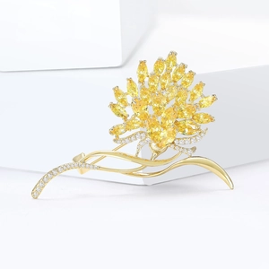 Elegant gold flower brooch with yellow marquise gems and white zircons on a pedestal