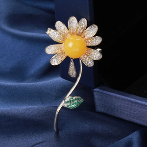 Elegant daisy brooch with yellow centerpiece and pavé cubic zirconia on blue silk