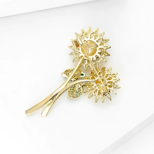 Detailweergave van de gouden zonnebloemspeld met veilige sluiting en groene zirkonia