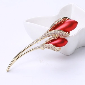 Macro detail of tulip brooch with red matte buds and sparkling cubic zirconia stones