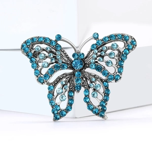 Exquisite hollow butterfly brooch with blue rhinestones on a minimalist white stone base