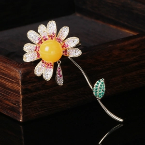 Macro detail of daisy brooch with yellow amber center and pave zircon flower petals